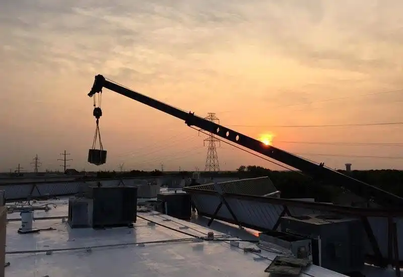 Crane lifting HVAC unit at sunset Calvary Chapel Plano Texas