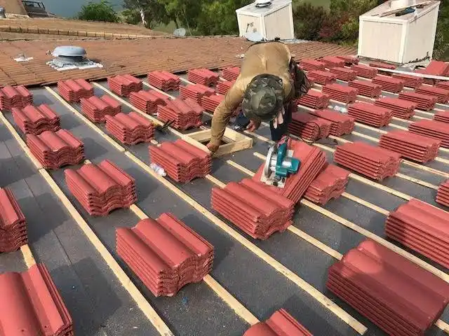 Roofer cutting clay tile on organized tile reroof Rockwall Texas